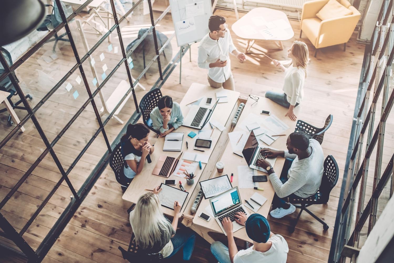 aerial view of young people working in a modern office - how professionals can prepare for harmonized sustainability reporting requirements