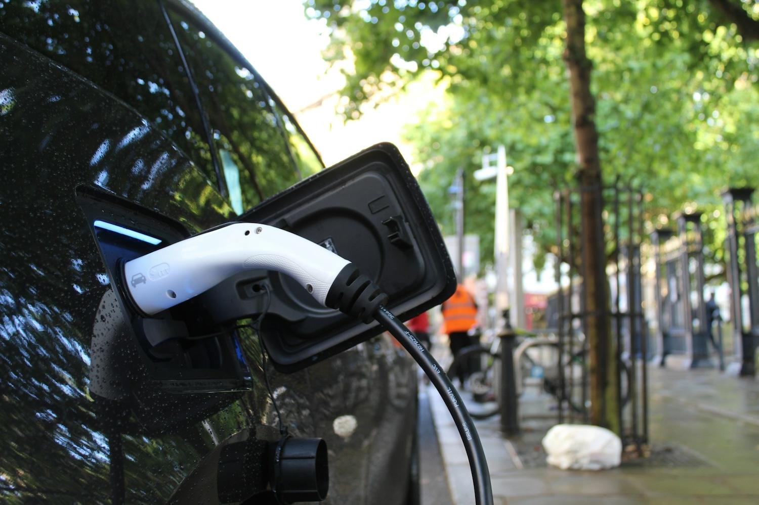 electric vehicle with charger plugged in - electric vehicles
